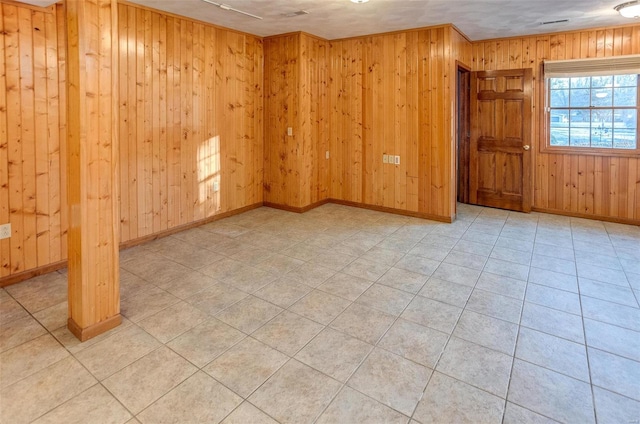 spare room with wooden walls and light tile patterned floors