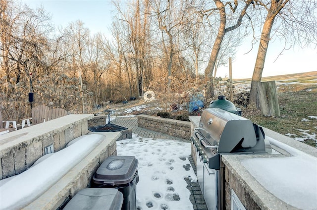 snow covered patio with a grill