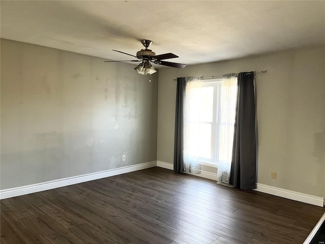 empty room featuring dark wood finished floors, baseboards, and ceiling fan