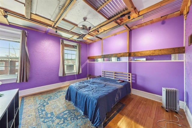 bedroom with radiator, ceiling fan, and hardwood / wood-style floors