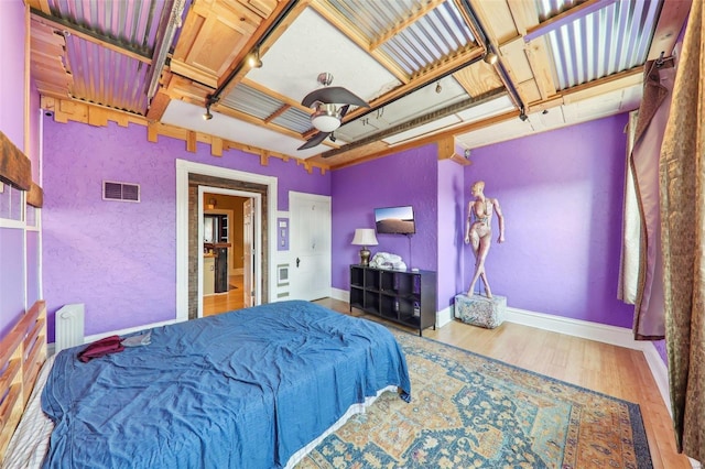 bedroom featuring radiator, ceiling fan, and wood-type flooring