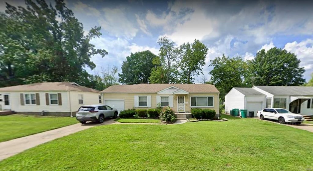 ranch-style house featuring a front lawn and a garage