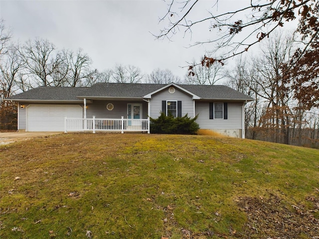 single story home with covered porch, a garage, and a front lawn