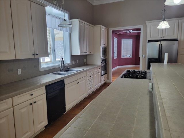 kitchen featuring black appliances, tile counters, white cabinets, and hanging light fixtures