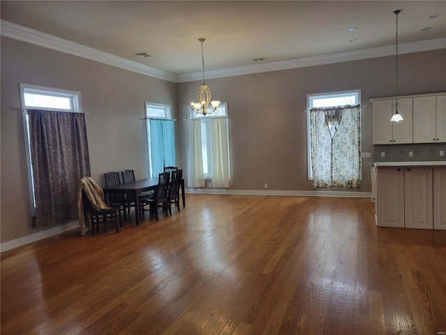 unfurnished dining area with plenty of natural light, wood-type flooring, ornamental molding, and a chandelier