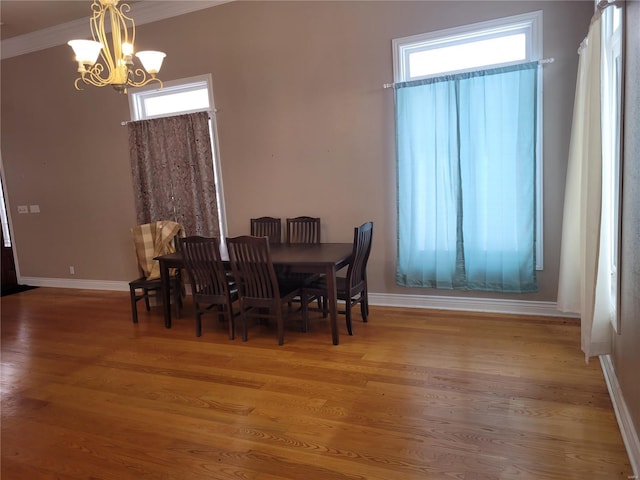 dining space with a chandelier, hardwood / wood-style floors, and ornamental molding