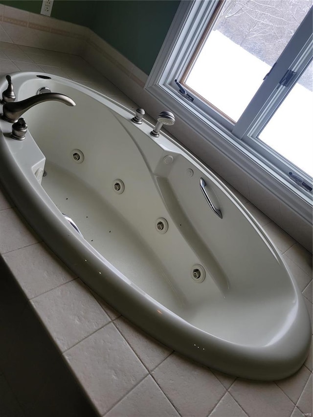 bathroom with tile patterned floors and a washtub