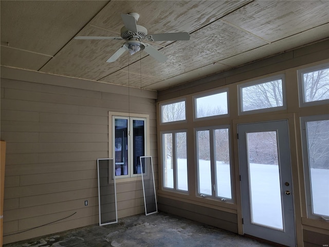 unfurnished sunroom featuring a wealth of natural light, ceiling fan, and wooden ceiling