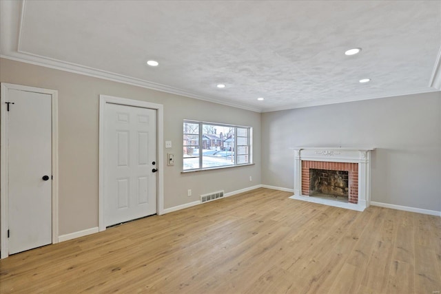 unfurnished living room featuring a brick fireplace, crown molding, and light wood-type flooring