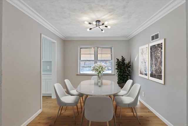 dining area featuring ornamental molding, wood-type flooring, and a notable chandelier