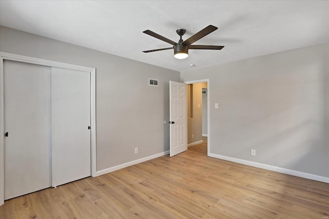 unfurnished bedroom featuring ceiling fan, a closet, and light hardwood / wood-style flooring