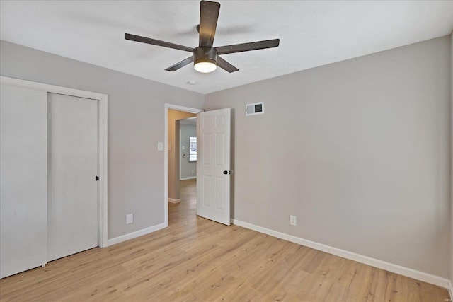 unfurnished bedroom with ceiling fan, a closet, and light hardwood / wood-style flooring