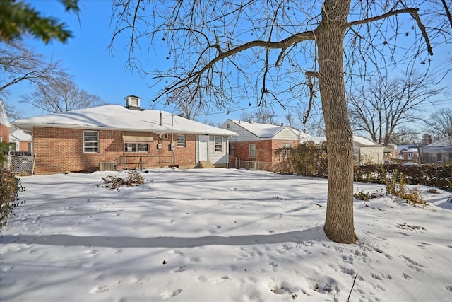 snow covered house featuring central air condition unit