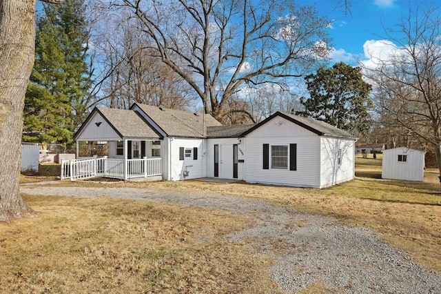 view of front facade featuring a front lawn, a porch, and a storage unit