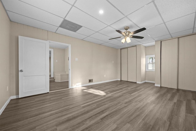 unfurnished bedroom with a paneled ceiling, ceiling fan, and dark wood-type flooring