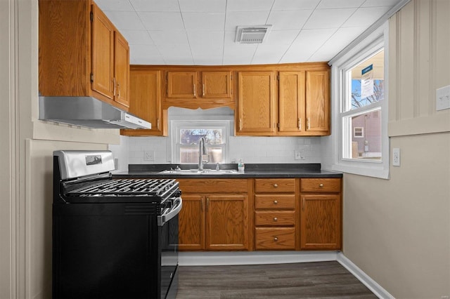 kitchen with black gas range, dark hardwood / wood-style flooring, sink, and backsplash