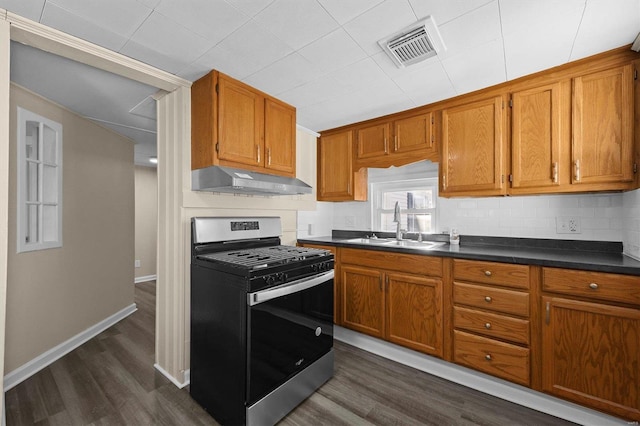 kitchen featuring gas range, backsplash, dark wood-type flooring, and sink