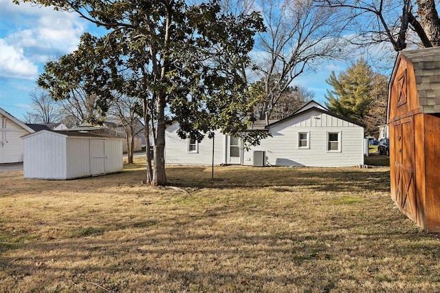 exterior space with a lawn, central air condition unit, and a storage unit