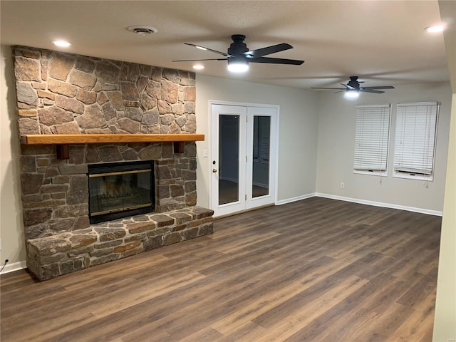 unfurnished living room featuring a fireplace, ceiling fan, and dark wood-type flooring