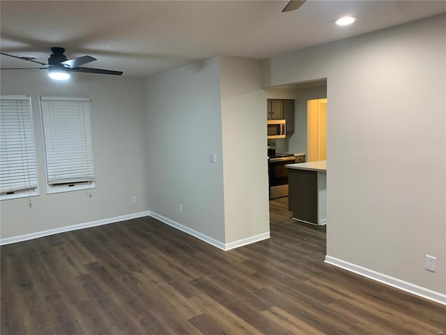 spare room with ceiling fan and dark hardwood / wood-style floors