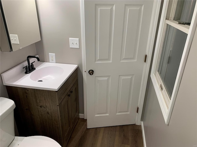 bathroom with hardwood / wood-style floors, vanity, and toilet