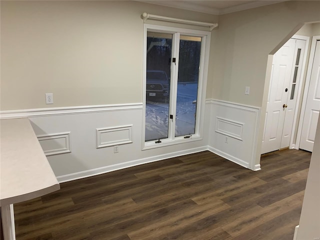 spare room with dark hardwood / wood-style floors and crown molding