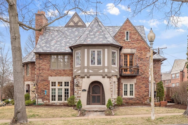 english style home featuring a front lawn