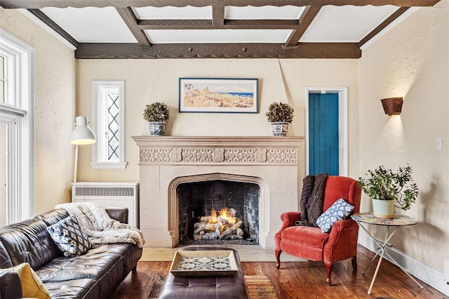 sitting room featuring beamed ceiling, wood-type flooring, and coffered ceiling