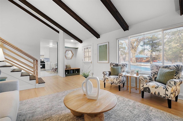 sitting room featuring high vaulted ceiling, light hardwood / wood-style floors, and beam ceiling