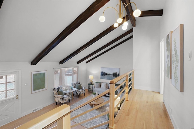 interior space with a wealth of natural light, light hardwood / wood-style floors, and beamed ceiling