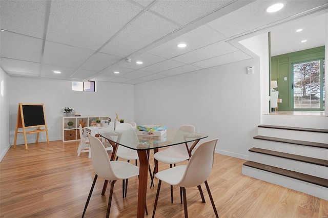 dining space featuring light hardwood / wood-style floors and a paneled ceiling