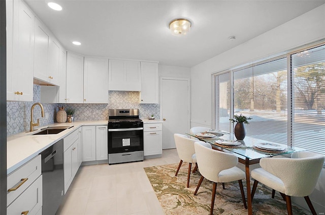 kitchen with sink, white cabinets, black dishwasher, stainless steel gas stove, and light tile patterned flooring