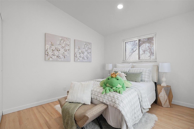 bedroom with vaulted ceiling and wood-type flooring