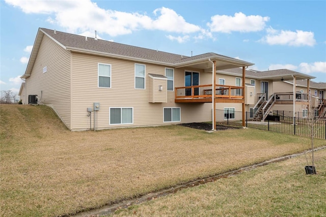 back of property with central air condition unit, a lawn, a wooden deck, and fence