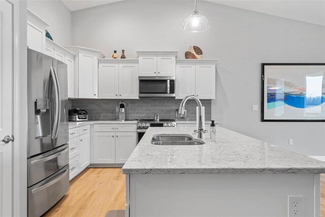 kitchen featuring a sink, appliances with stainless steel finishes, an island with sink, and white cabinets