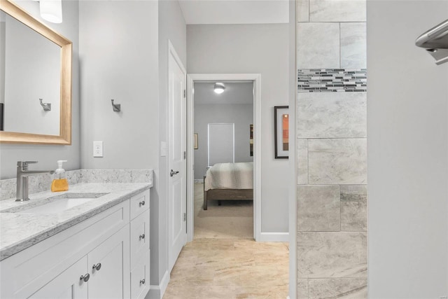 ensuite bathroom featuring connected bathroom, baseboards, and vanity