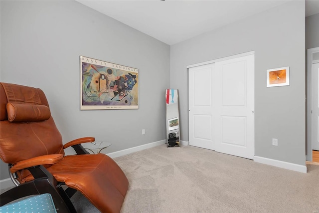 living area with baseboards and carpet