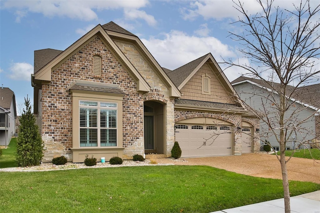 view of front of property with a garage and a front lawn