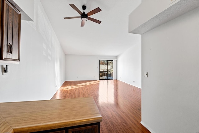 unfurnished living room featuring wood-type flooring and ceiling fan