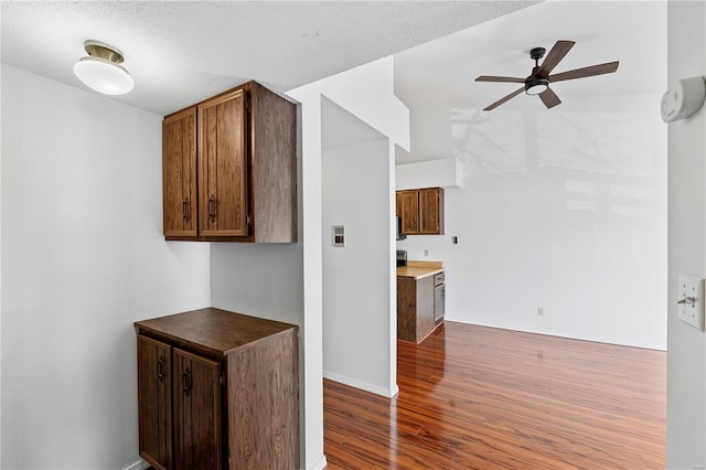 kitchen featuring ceiling fan, a textured ceiling, and hardwood / wood-style floors