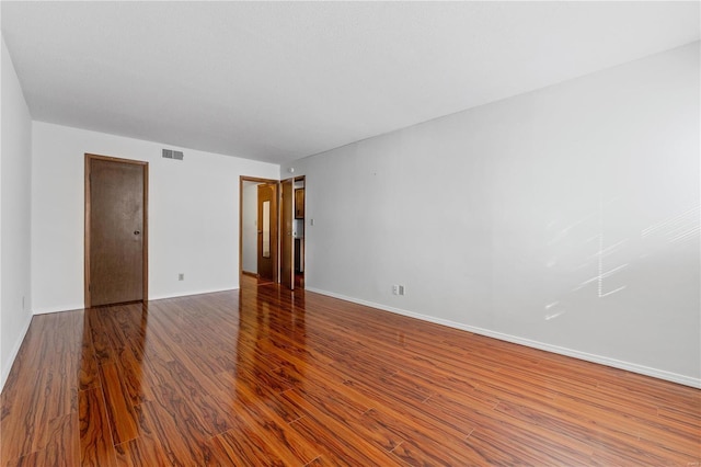 empty room with dark hardwood / wood-style flooring