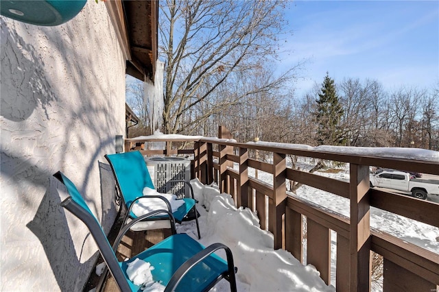 snow covered back of property featuring central air condition unit