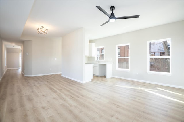 unfurnished living room featuring ceiling fan and light wood-type flooring