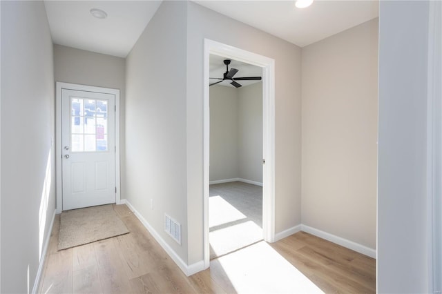 doorway with ceiling fan and light hardwood / wood-style floors