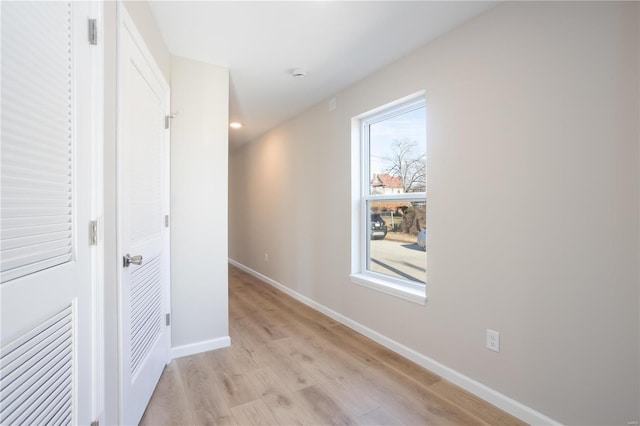 hall featuring a healthy amount of sunlight and light wood-type flooring