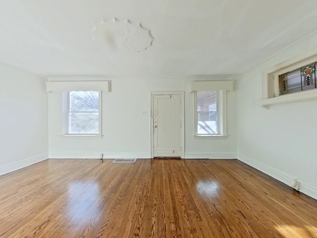 spare room with crown molding and light hardwood / wood-style flooring