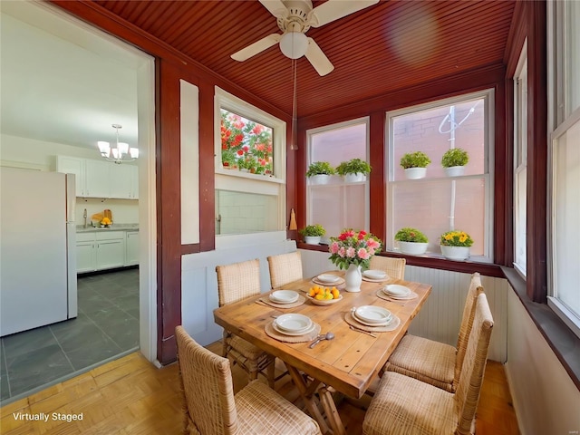 sunroom with ceiling fan with notable chandelier