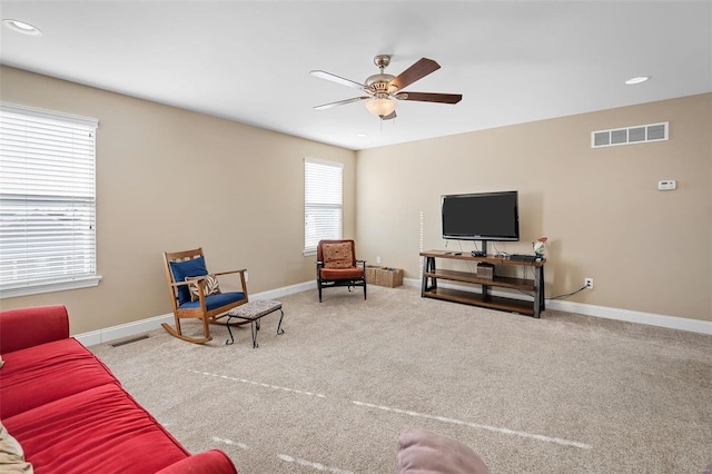 living room with ceiling fan and light colored carpet