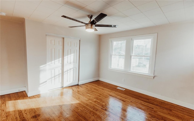 empty room with ceiling fan and light hardwood / wood-style floors