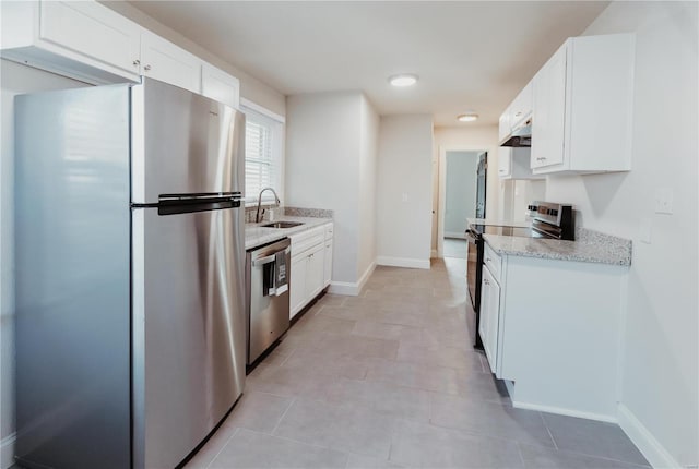 kitchen featuring white cabinetry, sink, light stone counters, and appliances with stainless steel finishes